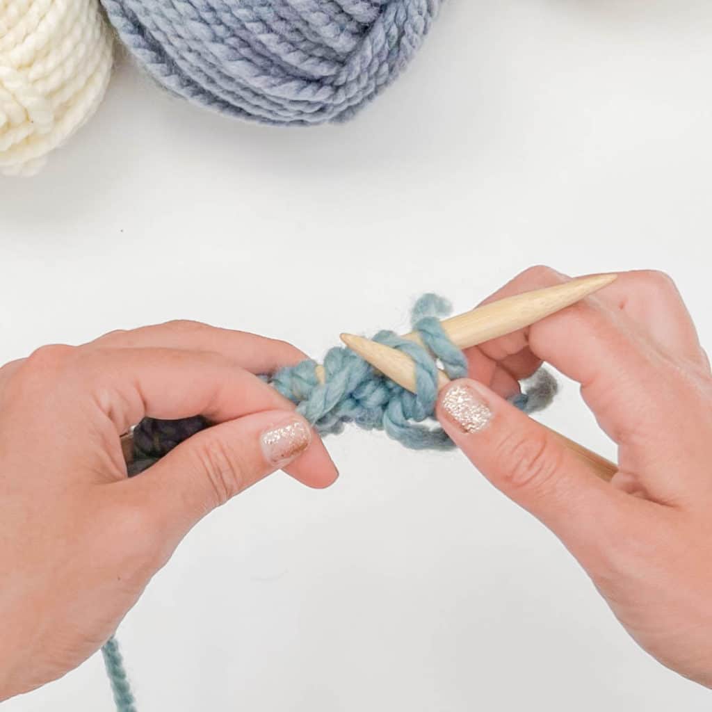 The working yarn is looped up and over (counter clockwise) around the right needle tip.