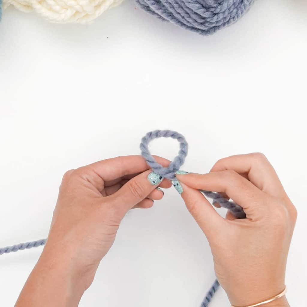 How to Tie a Slip Knot - Step 2.
Hands are brought together to form a loop with the yarn