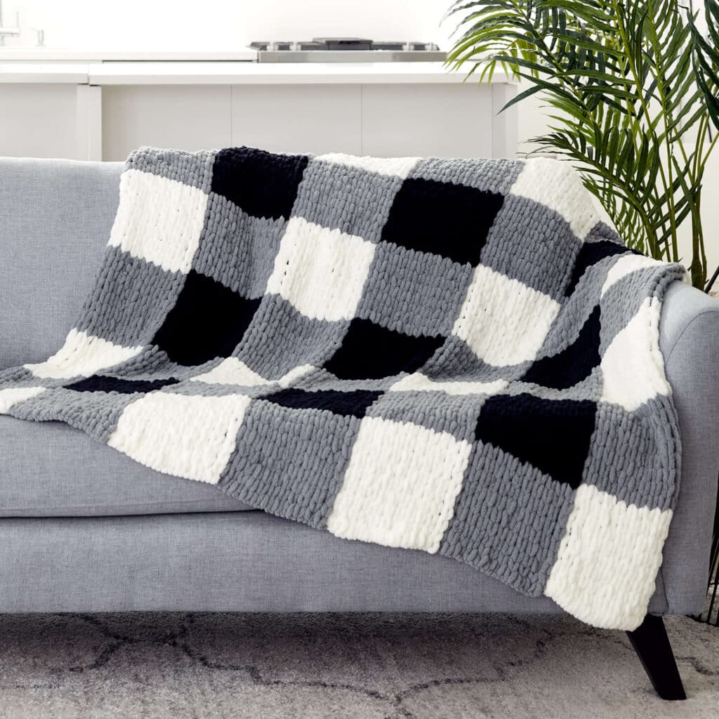 Image of a finger knit blanket draped on a sofa.