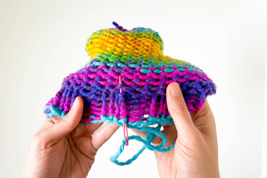 Image of a colorful beanie. It shows how yarn ends should be woven in.