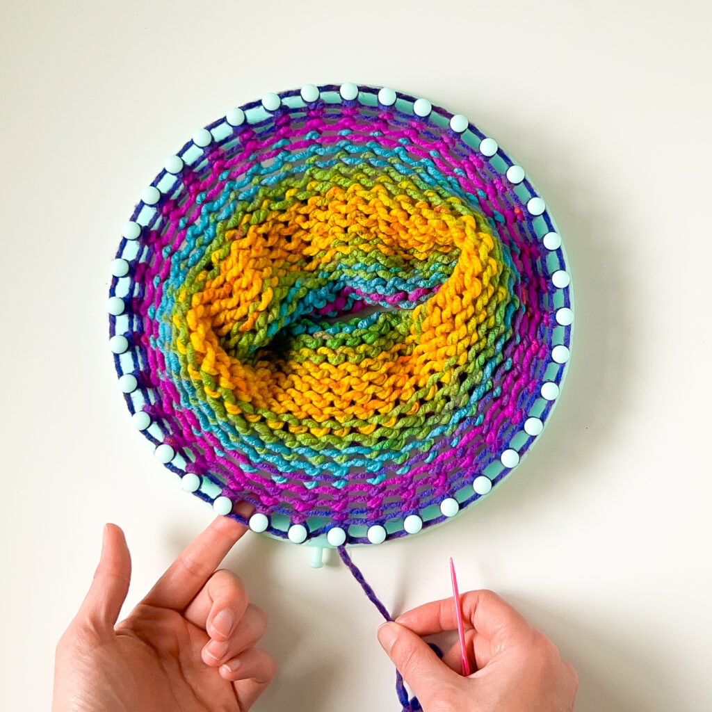 This image of an unfinished hat shows how loom knitting patterns look like during the creation process. 