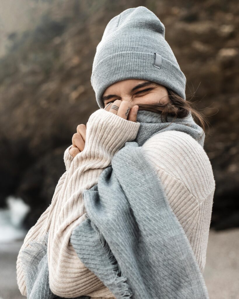 Woman holding her scarf to keep warm. This image if simply for decorative purposes showing off the free scarf knitting patterns in this blog!