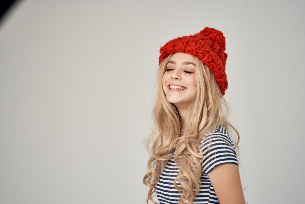 Image of a loom knit hat worn by a smiling woman.