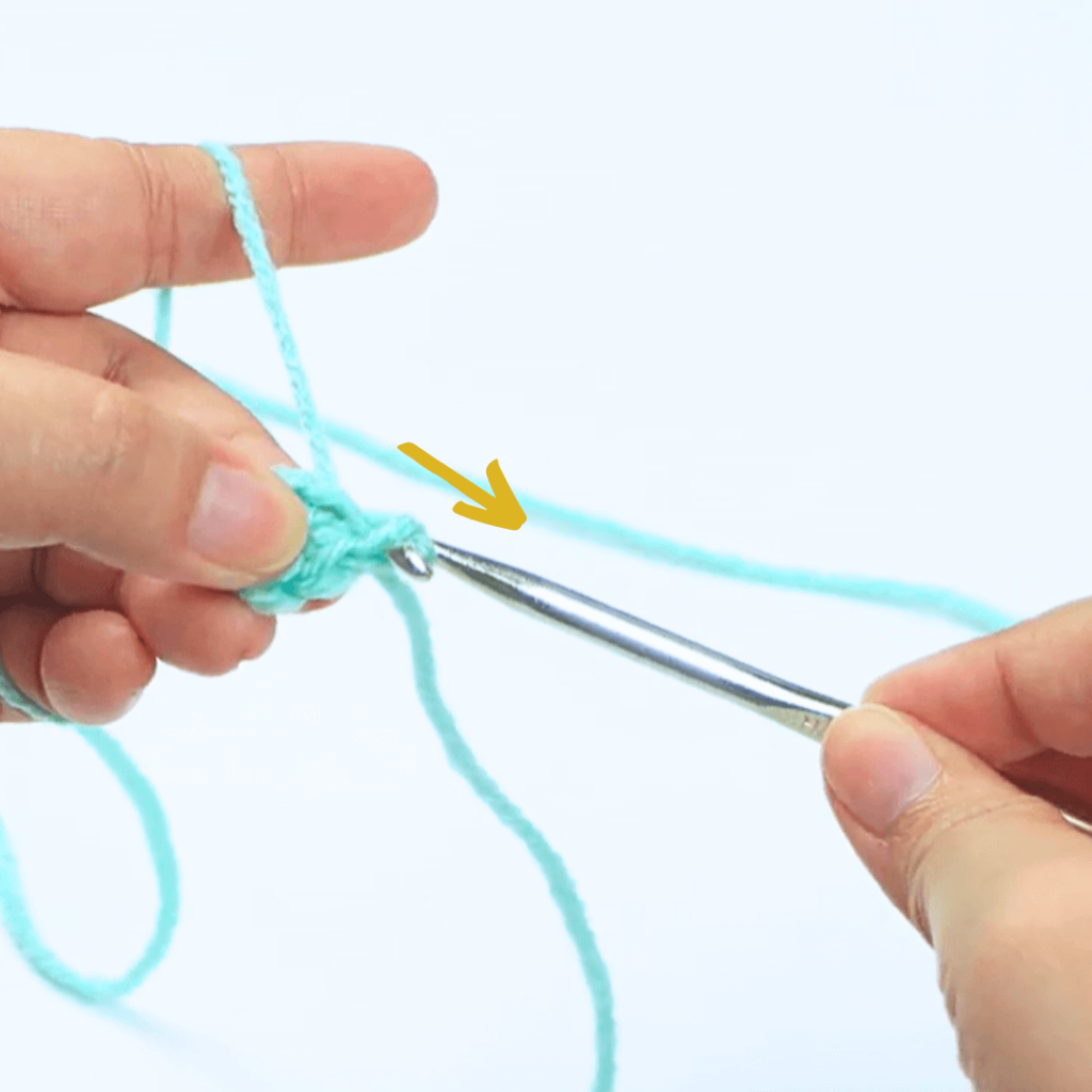 Step 2: Grab a loop

Grab a loop and pull it through the top of the stitch and through the loop on your hook.

Pro tip: Make sure your hook is facing towards you to have an easier time grabbing a loop.

Rotate your hook downward when pulling out a loop.