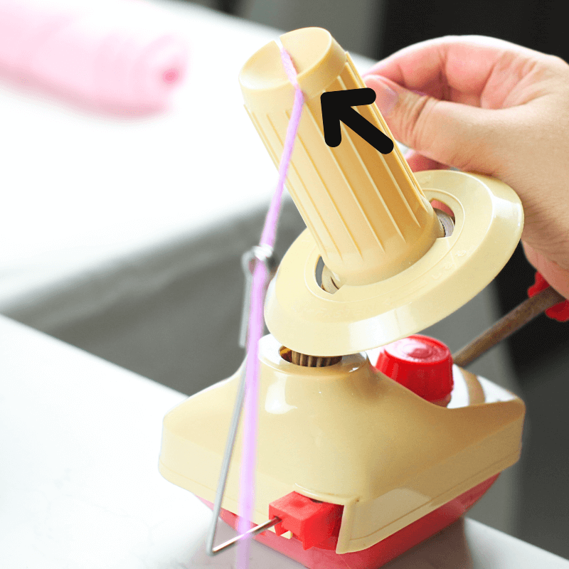 Step 2

Squeeze it in between the thin gaps in the middle of the spool/spindle.