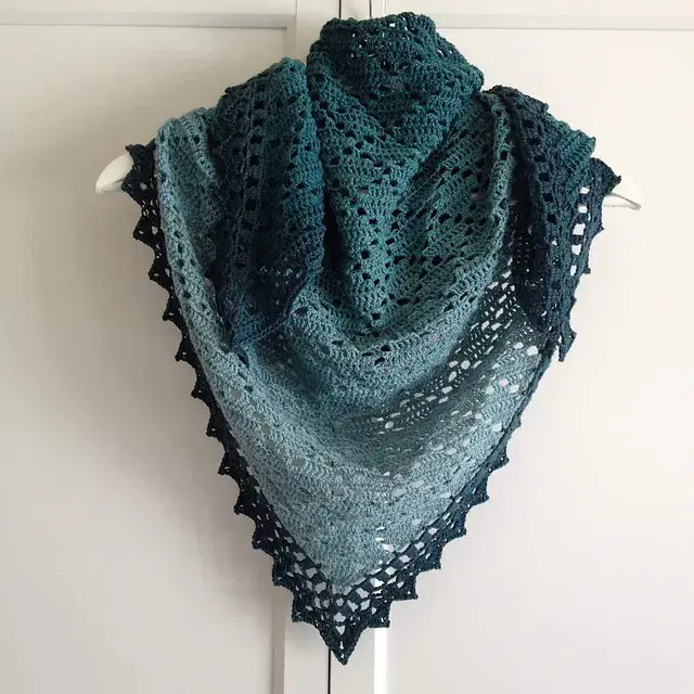 A filet crochet pattern in cool deep shades of blues.