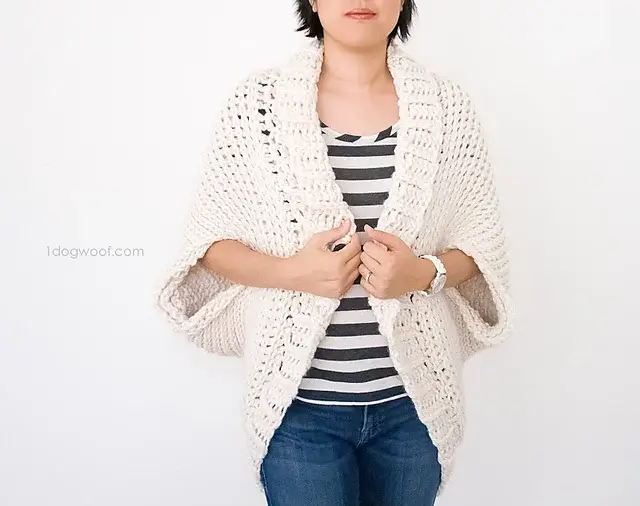 A woman wearing the featured crochet shrug pattern. It's cozy and thick, but still breathable.