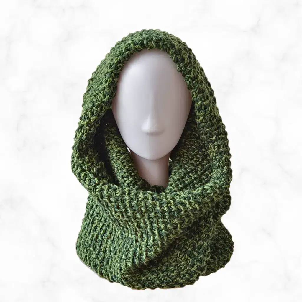 A forest green loom knit infinity scarf draped over a mannequin head.